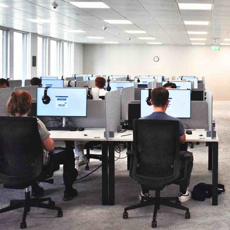 London office with an exam taking place, students facing away from the camera, sat at their laptops.