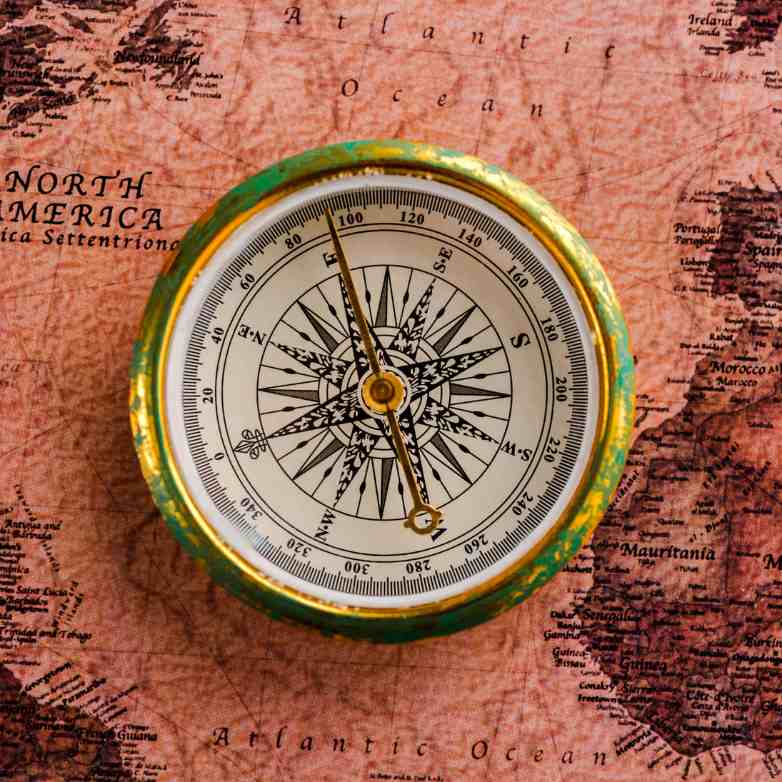 A golden compass on a red map